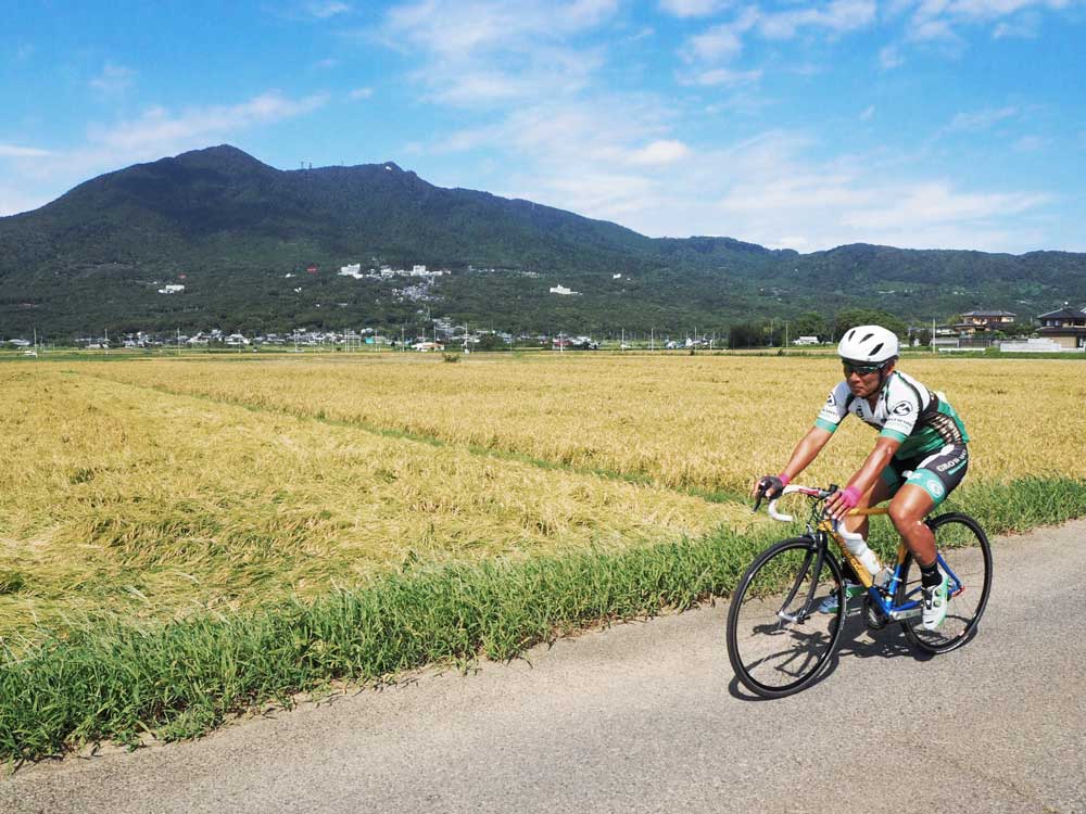 筑波山のふもとの田んぼ道を自転車で走る